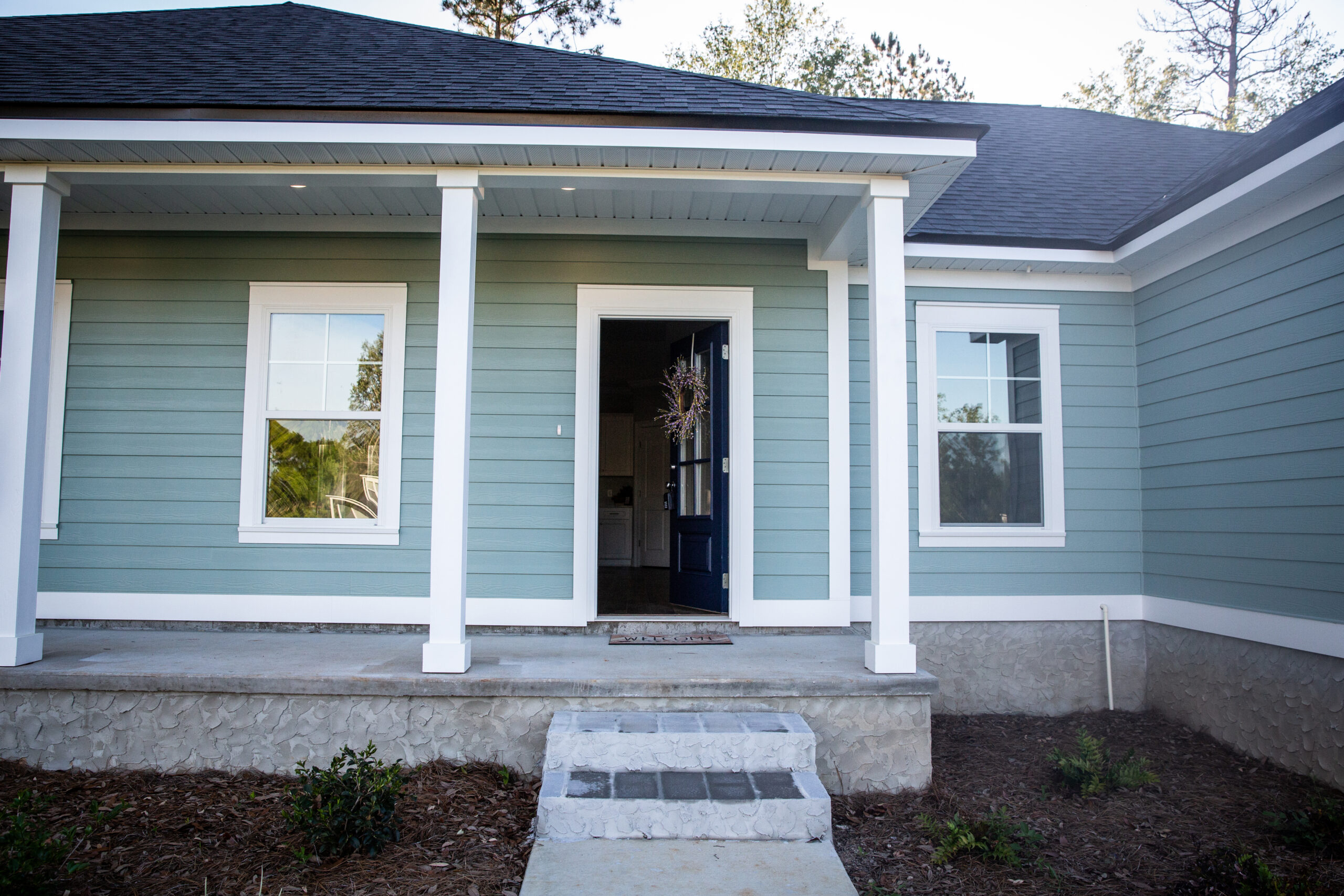 Front View of a Brand-New Construction House with Blue Vinyl Siding